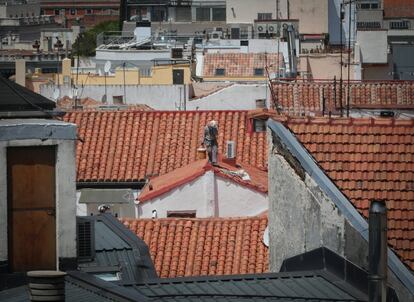 Un obrero reparando un tejado en el centro de Madrid.