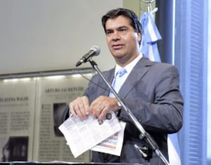 El jefe del Gabinete argentino, Jorge Capitanich, hace trizas dos páginas del diario 'Clarín' el 2 de febrero, en una rueda de prensa.