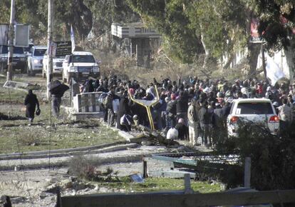 Civilians gather before being evacuated with the help of Syrian Red Crescent and United Nations personnel from a besieged area of Homs February 9, 2014. Six hundred people left the besieged ruins of rebel-held central Homs on Sunday, escaping more than a year of hunger and deprivation caused by one of the most protracted blockades of Syria's devastating conflict. The evacuees, mainly women, children and old men, were brought out by the United Nations and Syrian Red Crescent on the third day of an operation during which the aid convoys came under fire and were briefly trapped themselves in the city. Picture taken February 9, 2014. REUTERS/Thaer Al Khalidiya (SYRIA - Tags: POLITICS CIVIL UNREST CONFLICT)