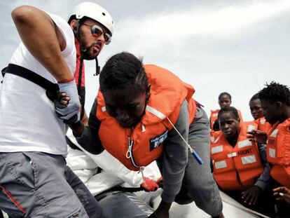 El mediador cultural Salah Dasuki ayuda a subir al dignity I a varios inmigrantes rescatados.