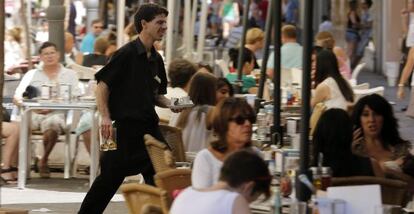 Un camarero trabaja en una terraza en Valencia. 