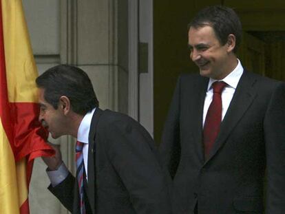 Miguel Ángel Revilla besa la bandera española ante José Luis Rodríguez Zapatero a la entrada de La Moncloa.