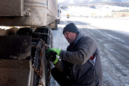 Robert Arnold, de Denver, Colorado, coloca cadenas en los neumáticos de su semirremolque en Silverthorne, Colorado.