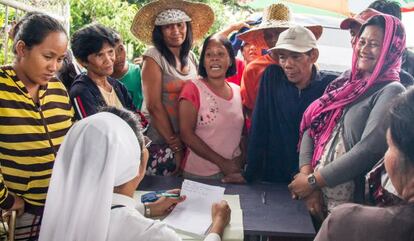 La hermana Jessica, salesiana encargada de gestionar el reparto de las ayudas, apunta los nombres de aquellos que ya las han recibido. Kananga, Leyte.