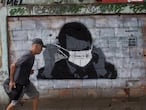 A man walks past a graffiti of Brazil's President Jair Bolsonaro wearing a protective mask during the new coronavirus outbreak in Rio de Janeiro, Brazil, Tuesday, April 7, 2020. (AP Photo/Silvia Izquierdo)