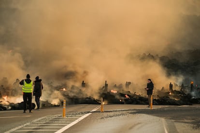 Varios periodistas trabajan cerca de la lava expulsada por el volcn.
