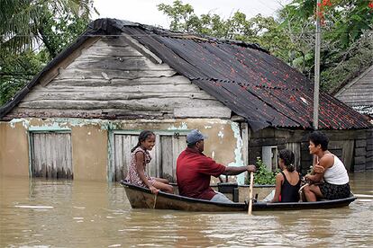 Una familia se traslada en bote en la localidad cubana de Isabel Rubio, anegada por las lluvias.