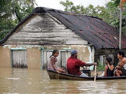 Una familia se traslada en bote en la localidad cubana de Isabel Rubio, anegada por las lluvias.