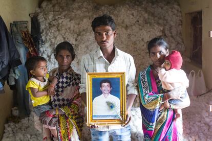 Sobre kilos de algodón acumulados en su casa, en el pueblo de Shivnagar, Ganesh Sachnkarraw Pandet muestra la foto de su padre, víctima de la oleada de suicidios por la crisis agraria en la región). Junto a él, su mujer, sus hijos, su hermana y su madre, Rekha Sachnkarraw Pandharkar.