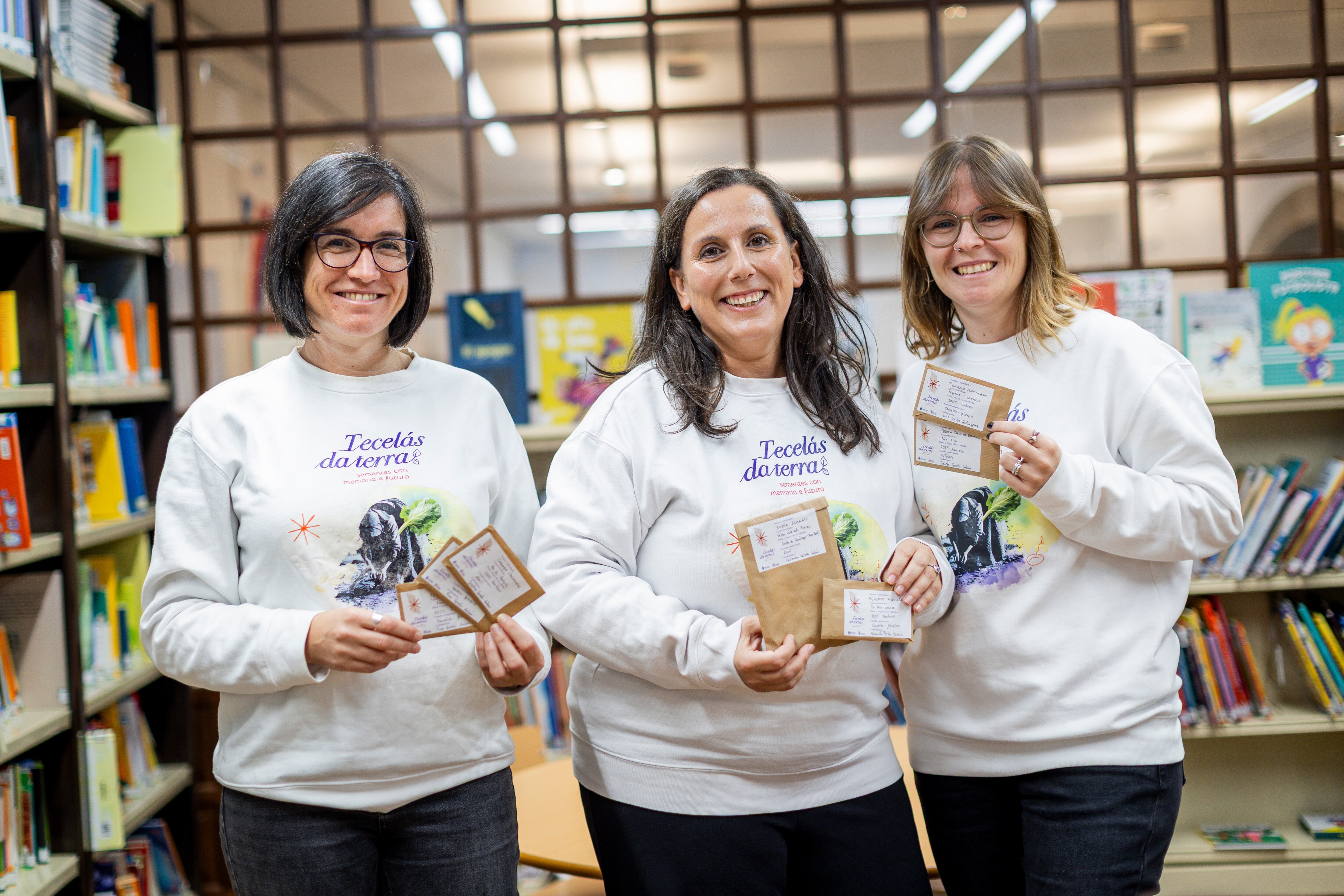 Noelia Darriba, Raquel Teijeiro y Tania Merelas, fundadoras de Tecelás da Terra en la biblioteca de Betanzos.