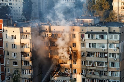 Los equipos de emergencias trabajaban este domingo sobre la fachada de uno de los edificios de Kiev alcanzados por el bombardeo ruso.