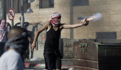 Un joven palestino apunta a las fuerzas de seguridad durante los enfrentamientos en el barrio árabe de Shuafat, en Jerusalén.