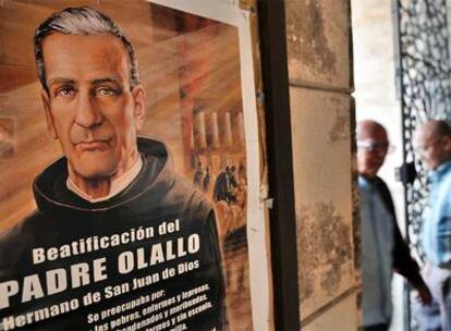 Dos hombres pasan el jueves junto a un cartel que anuncia la beatificación del padre José Olallo.