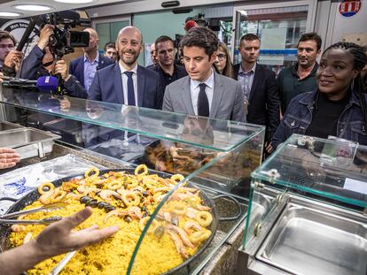 El primer ministro de Francia, Gabriel Attal (en el medio, con traje gris), durante una visita a un mercado en París, este martes.