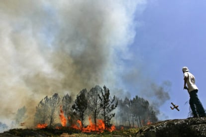 Una avioneta arroja agua sobre el fuego que destruye un bosque de la localidad de Soajo, al norte de Portugal.