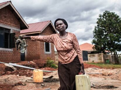 Betty Nakiberu, una de las cooperativistas, frente a su vivienda durante la construcción.