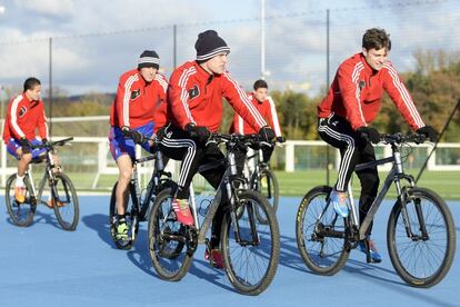 Un grupo de jugadores del Basilea llegan en bicicletas al entrenamiento de su equipo.