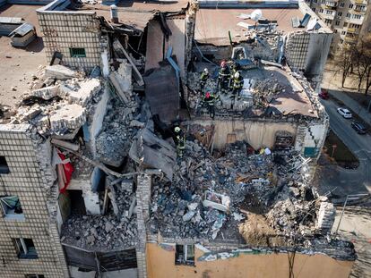 Varios bomberos trabajan este jueves entre las ruinas de un edificio residencial bombardeado en Kiev.