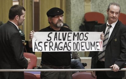 Un miembro de la plataforma ciudadana creada en defensa de As Fragas es desalojado ayer del Parlamento gallego.