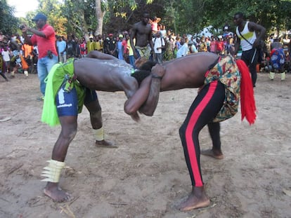 Dos jóvenes luchan bajo la mirada de los asistentes a la fiesta en Youtou, Senegal.