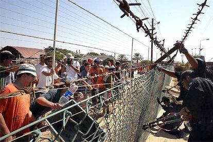 Policías israelíes cortan las vallas de Neve Dekalim, cerradas por los colonos para impedirles la entrega de la orden de evacuación de Gaza.