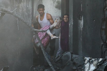 Un hombre traslada a una niña herida tras los ataques israelíes en Jan Yunis, en la franja de Gaza. 