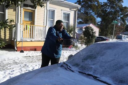 Una mujer vierte agua en el parabrisas de su vehículo para quitar el hielo en Savannah, en el estado de Georgia, el 4 de enero de 2018.