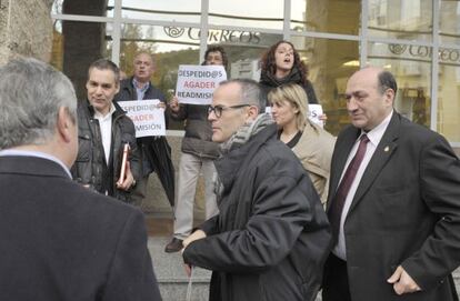 El conselleiro Jesús Vázquez y el delegado de la Xunta en Ourense, Rogelio Martínez, pasan ante trabajadores de Agader en una protesta.