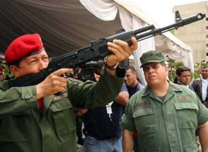 El presidente venezolano, Hugo Chávez, prueba el nuevo modelo de fusil de asalto ruso Kalashnikov, el AK-103, ante el ministro de Defensa, Orlando Maniglia, en junio en Caracas.