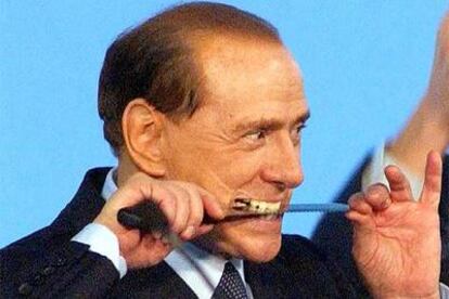 Silvio Berlusconi bromea con un cuchillo antes de cortar una tarta en un mitin de Forza Italia en Venecia.