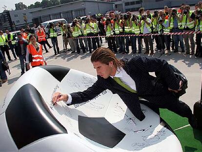 Sergio Ramos firma en un balón de Kamen a su llegada a la concentración de España en Alemania.