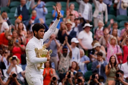 Carlos Alcaraz, con la copa de Wimbledon, saluda a la afición en la pista central. 