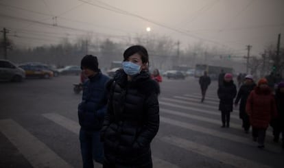 Una mujer camina por Pekín con mascarilla durante la crisis de contaminación de enero pasado.