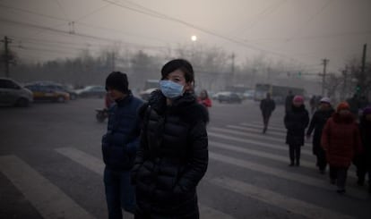 Una mujer camina por Pek&iacute;n con mascarilla durante la crisis de contaminaci&oacute;n de enero pasado.