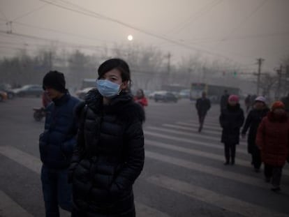 Una mujer camina por Pek&iacute;n con mascarilla durante la crisis de contaminaci&oacute;n de enero pasado.