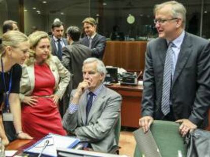 El vicepresidente económico de la Comisión Europea, Olli Rehn (dcha), conversa con el comisario europeo de Mercado Interior y Servicios Financieros, Michel Barnier (c), hoy antes del inicio del Consejo de ministros europeos de Economía y Finanzas (Ecofin) en Bruselas (Bélgica).