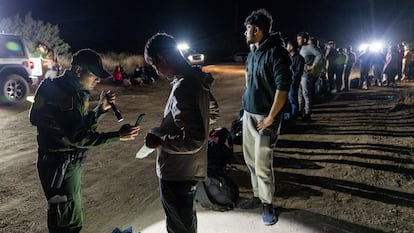 Migrantes hacen fila para ser procesados por la Patrulla Fronteriza tras cruzar a Estados Unidos desde México, en Jacumba Hot Springs (California), en junio de 2024.