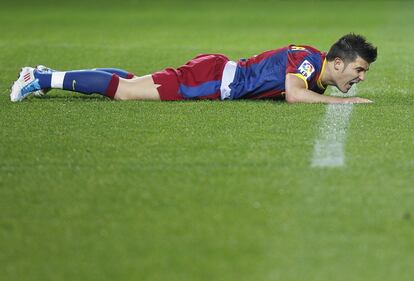 Villa en el suelo, durante el partido contra el Sevilla, correspondiente a la vigésimo octava jornada del Campeonato Nacional de Liga de Primera División que enfrenta a ambos equipos en el estadio Ramón Sánchez Pizjuán.