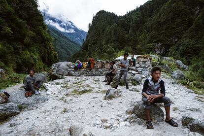 Las personas que trabajan en las montañas caminan durante semanas para entregar suministros esenciales a los habitantes de la zona. En la zona, varios trabajadores se toman un merecido descanso en un mirador de Namche Bazar (Nepal).