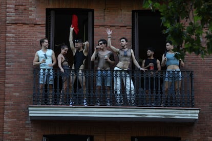 Varias personas bailan en el balcón de una vivienda durante la marcha del Orgullo en Madrid. 