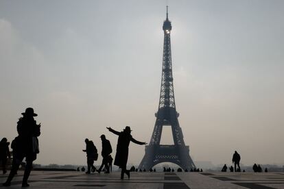 Una mujer posa junto a la Torre Eiffel de París (Francia). 

