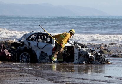 Un bombero de la ciudad de Fremont revisa vehículos que fueron arrastrados al Océano Pacífico mientras realiza tareas de búsqueda y rescate después de las fuertes lluvias en Montecito, California, el 10 de enero de 2018.