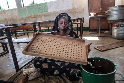 Una operaria cuenta los mármoles que serán utilizados por los votantes en una mesa electoral en el distrito de Tallinding de Serekunda, en vísperas de las elecciones presidenciales de Gambia.