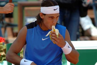 Rafael Nadal come un plátano durante un descanso de su partido contra Nowak Djokovic.