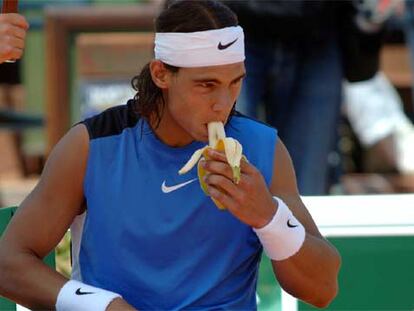 Rafael Nadal come un plátano durante un descanso de su partido contra Nowak Djokovic.