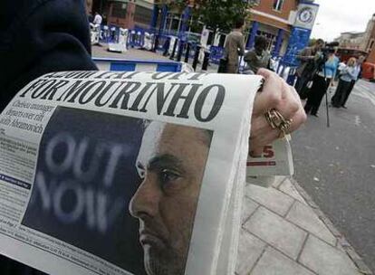 Una mujer, en Londres, con un periódico en el que se informa de la salida de Mourinho.