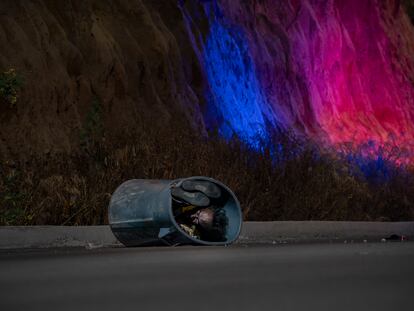 Patrol lights illuminate the road in Tijuana at the site where a migrant corpse was dumped.