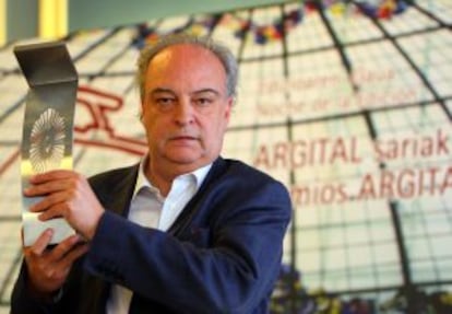 Enrique Vila-Matas sostiene el premio que le han concedido los editores vascos.