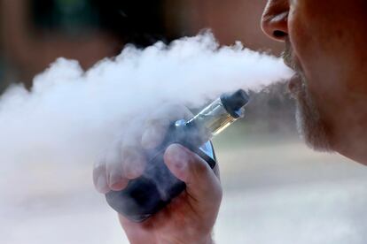 A man smokes a liquid containing THC from an e-cigarette, in August 2019.