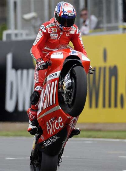 Casey Stoner realiza un caballito con su moto tras ganar en Donington Park.